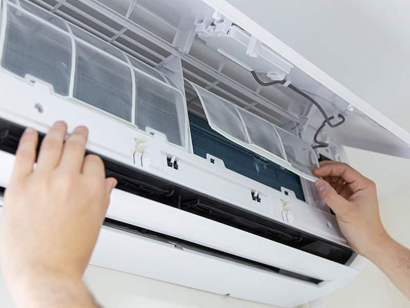 Male technician cleaning air conditioner indoors. technician service cleaning the conditioner, filter change